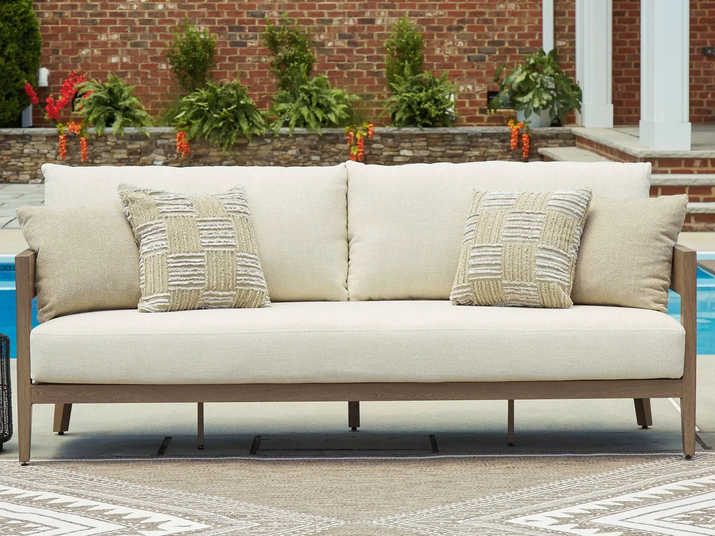 Serene Bay sofa with cushions in beige fabric and dark brown wooden frame on outdoor patio on Tampa Home & Garden Store