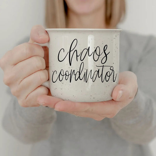 Chaos Coordinator coffee mug by Gia Roma in speckled white ceramic, held in hands on Tampa Home & Garden Store