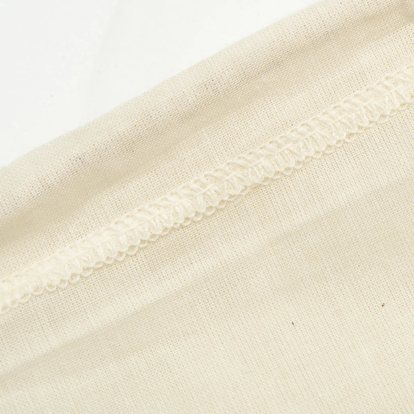 Beige linen fabric close-up with a stitched seam on Tampa Home & Garden Store