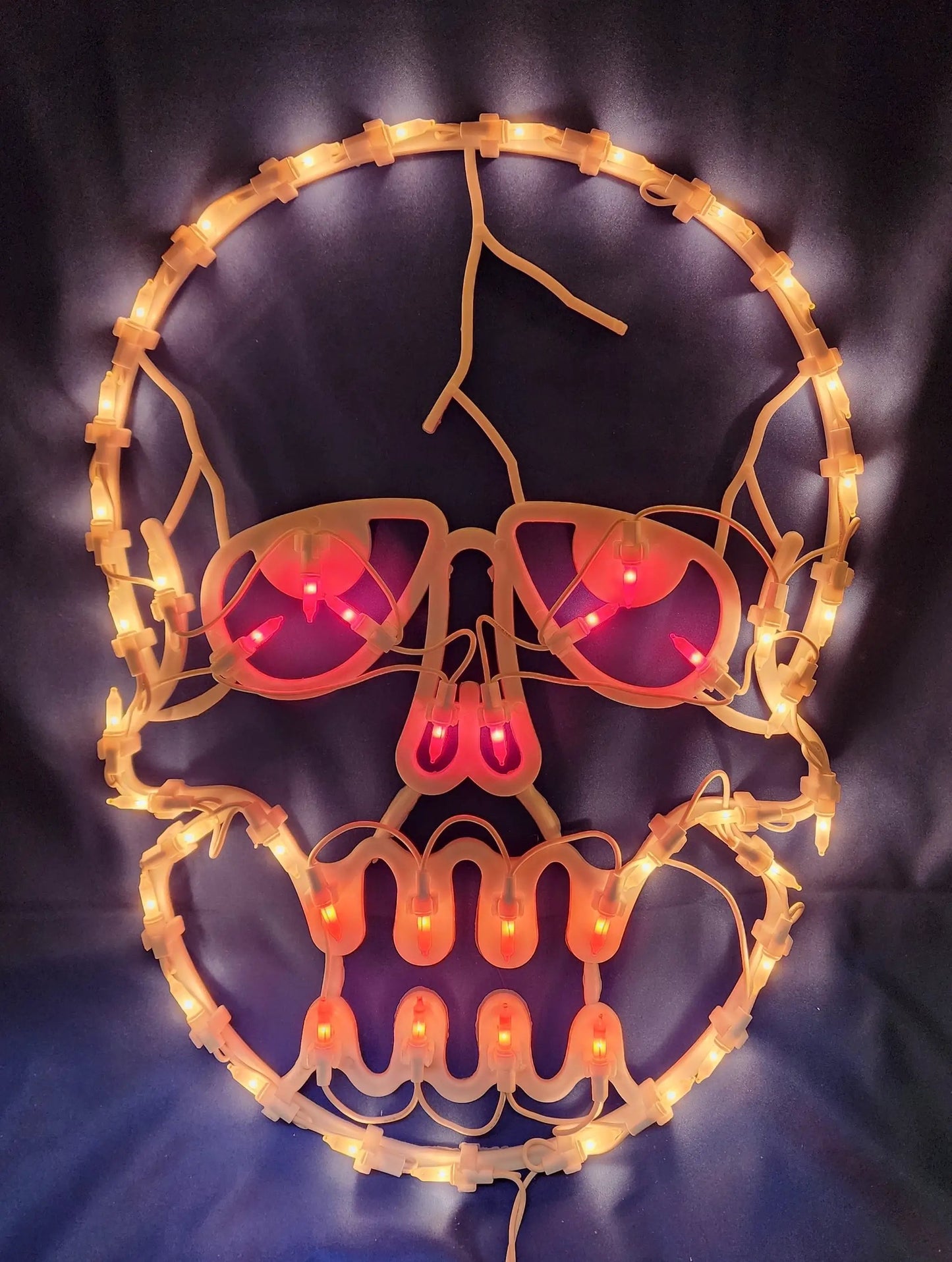 Fifty Light Halloween Skull Window Sculpture warm yellow LEDs surround a pink skull design on Tampa Home & Garden Store