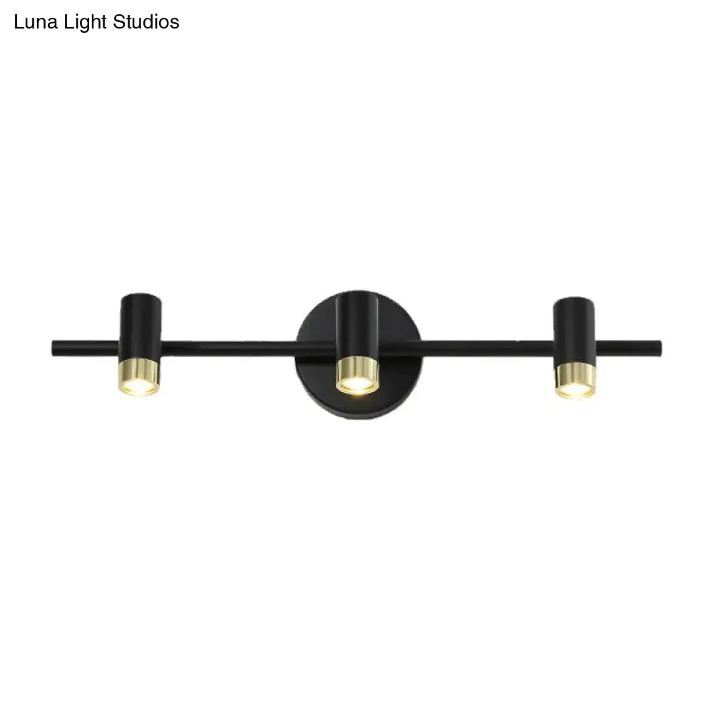Black brass vanity sconce with three cylindrical light heads on a horizontal bar Decorbites on Tampa Home & Garden Store
