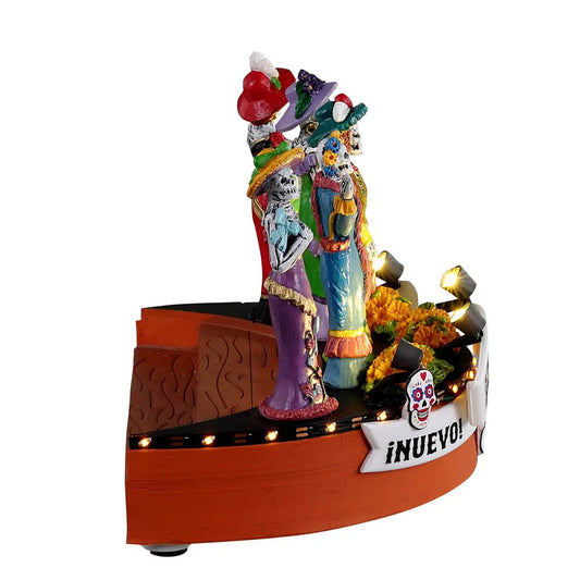 Catarinas Dia De Muertos fashion show figurines on a lit village platform on Tampa Home & Garden Store