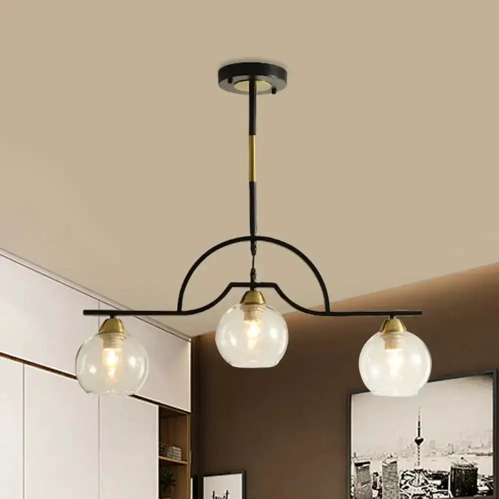 Pendant light with black and brass arch and three clear glass globes over kitchen on Tampa Home & Garden Store