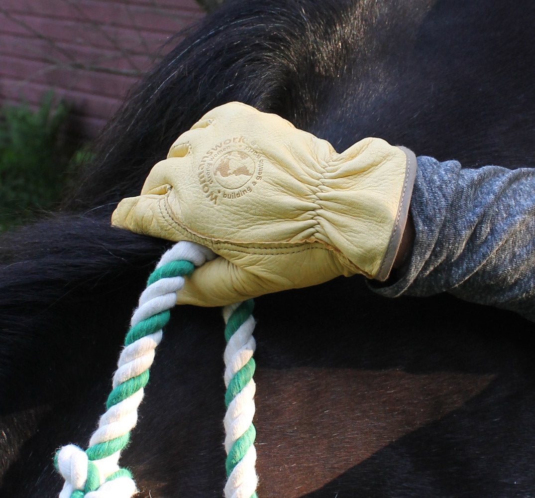 Women's beige Deerskin Work Glove by Womanswork gripping a green and white twisted rope on Tampa Home & Garden Store