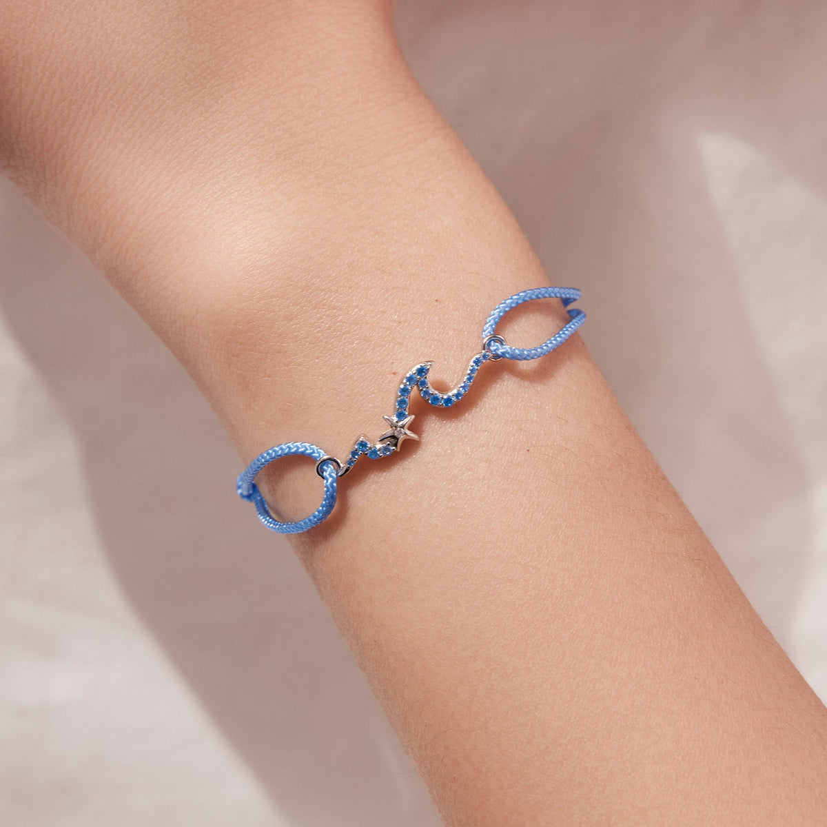 Sterling silver adjustable bracelet with blue CZ pendants on a blue cord band on Tampa Home & Garden Store