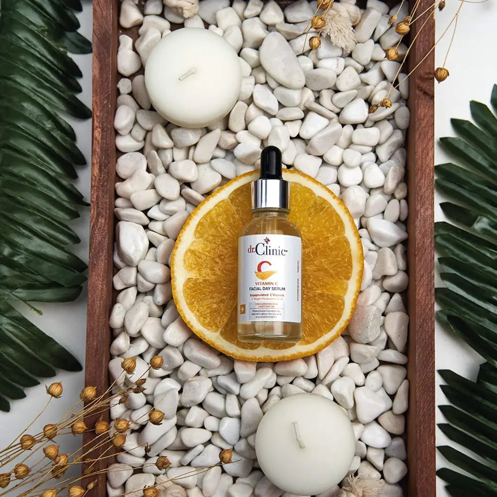 Dr.Clinic Vitamin C Facial Day Serum bottle on orange slice amid white pebbles in a wooden tray on Tampa Home & Garden Store