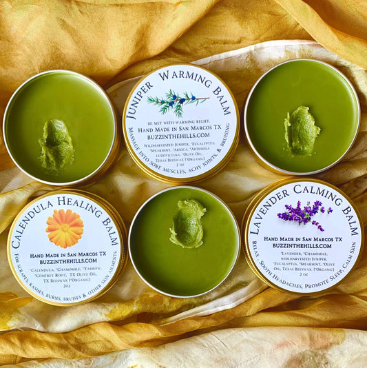 Juniper Warming Balm tins with green balm in metal containers on gold fabric on Tampa Home & Garden Store