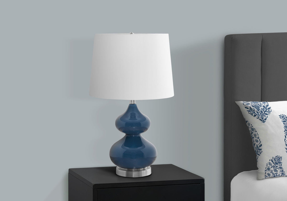Table lamp with cobalt blue ceramic base and white shade on a black nightstand on Tampa Home & Garden Store