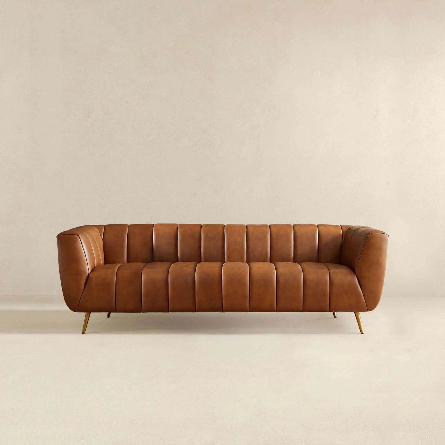 Ava sofa in gold tan leather with channel tufting and slender gold legs on Tampa Home & Garden Store