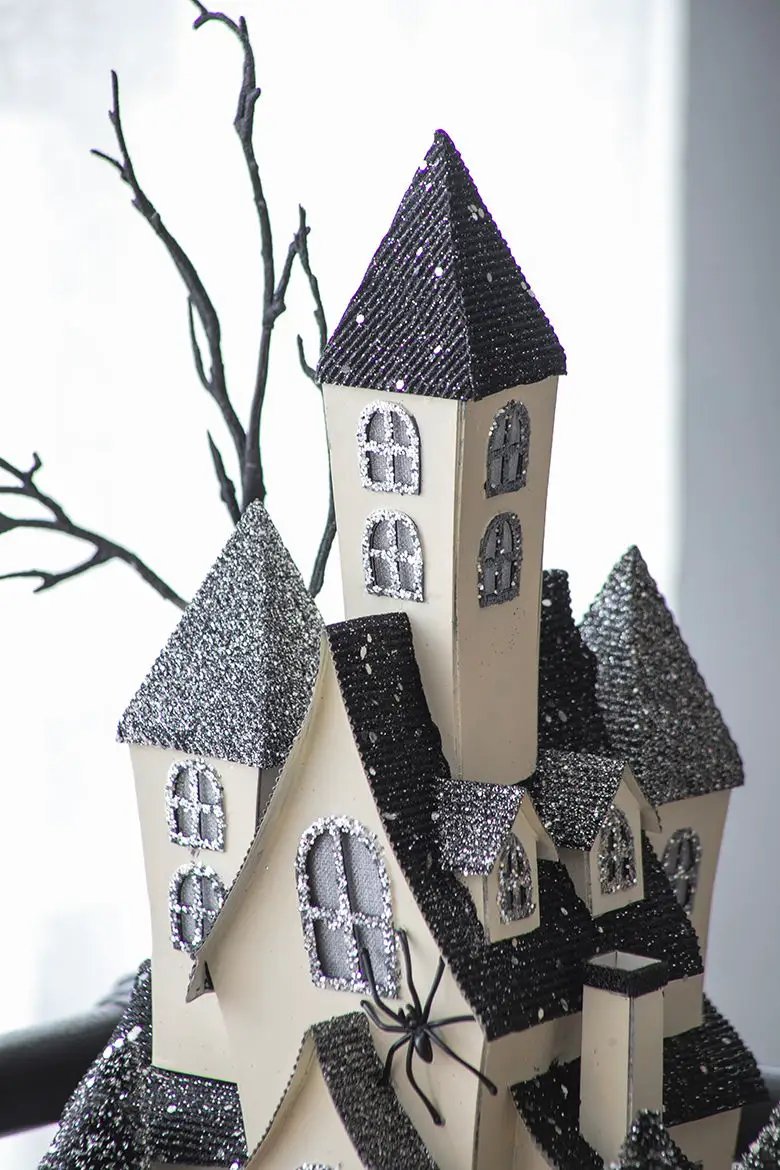 Cardboard lighted haunted house sculpture beige walls with glittery black roofs on Tampa Home & Garden Store