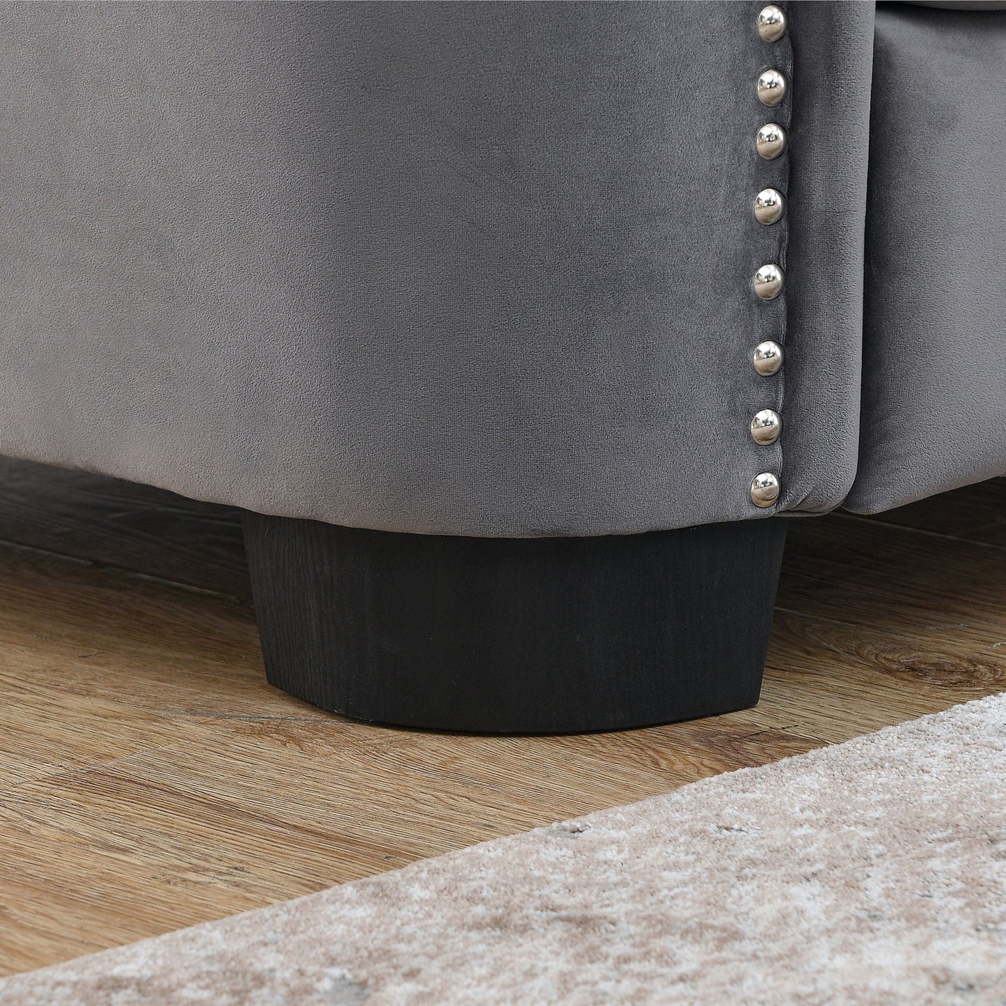 Modern Chesterfield sofa close-up in charcoal gray fabric with silver button seam on Tampa Home & Garden Store