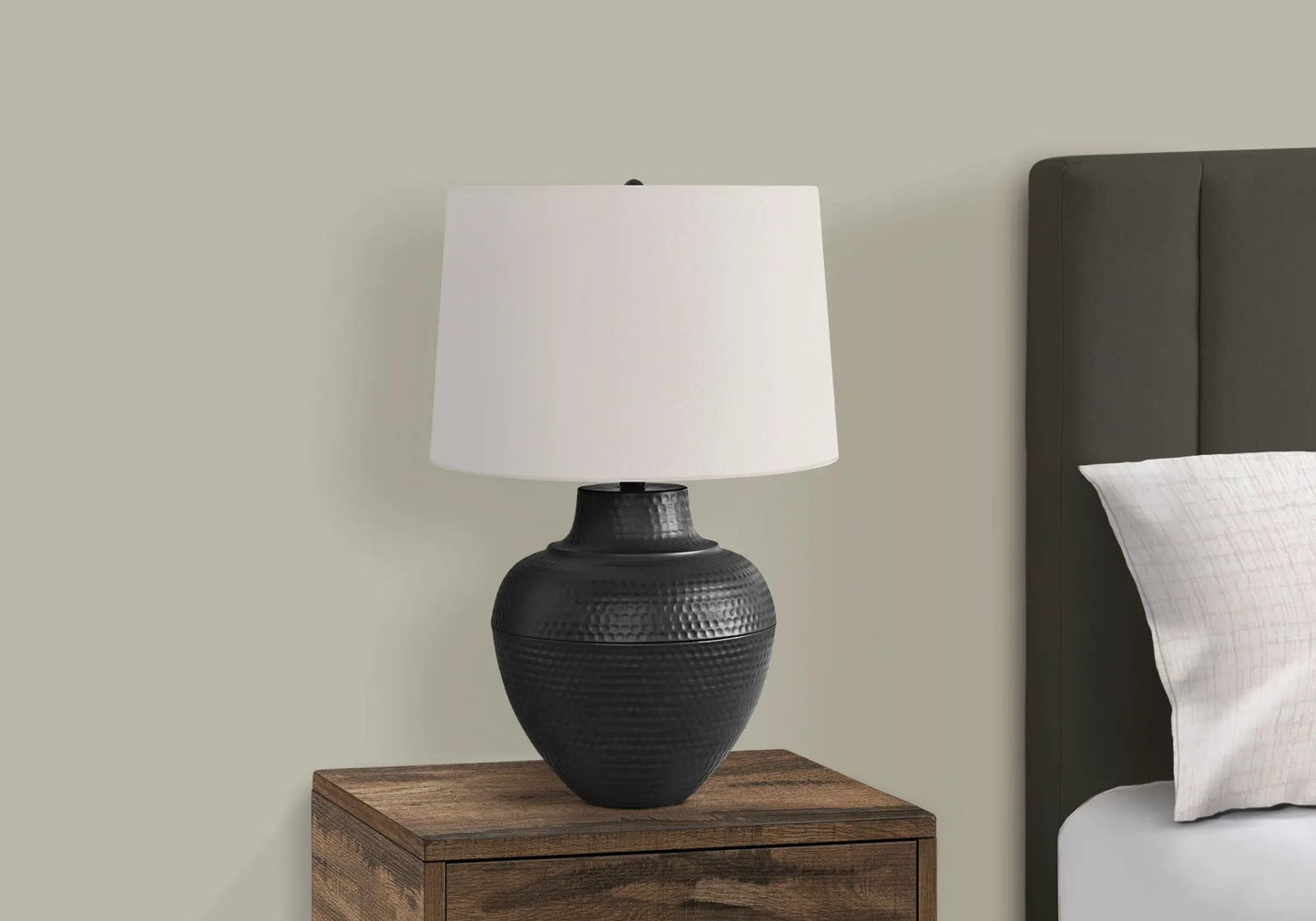 Table lamp in black hammered ceramic with white fabric shade on a wooden nightstand on Tampa Home & Garden Store