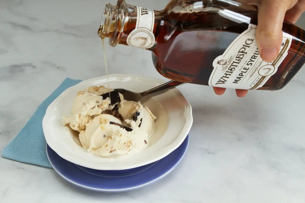 Whistlepig Rye Whiskey Barrel-Aged Maple Syrup poured over vanilla ice cream in a white bowl on Tampa Home & Garden Store