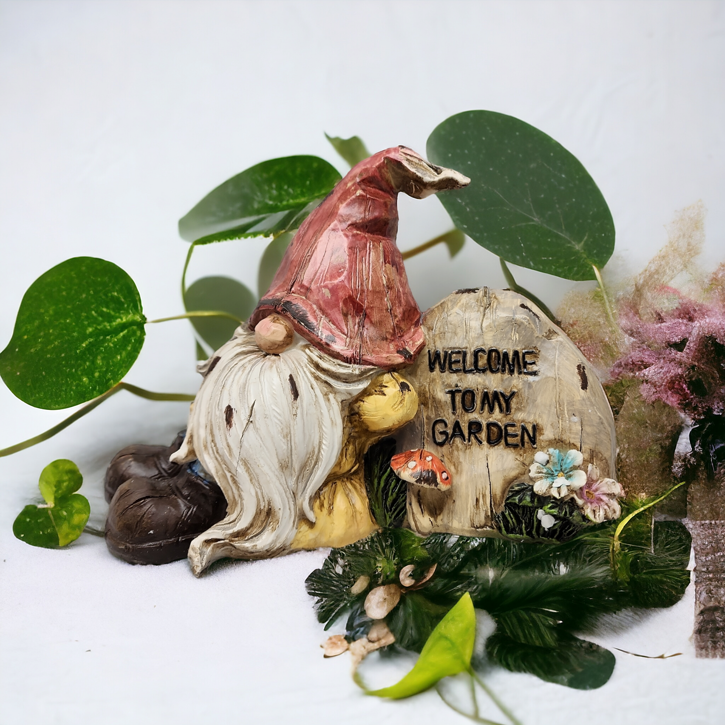 Resting 8-inch gnome on a carved log with Welcome to My Garden inscription amid greenery on Tampa Home & Garden Store