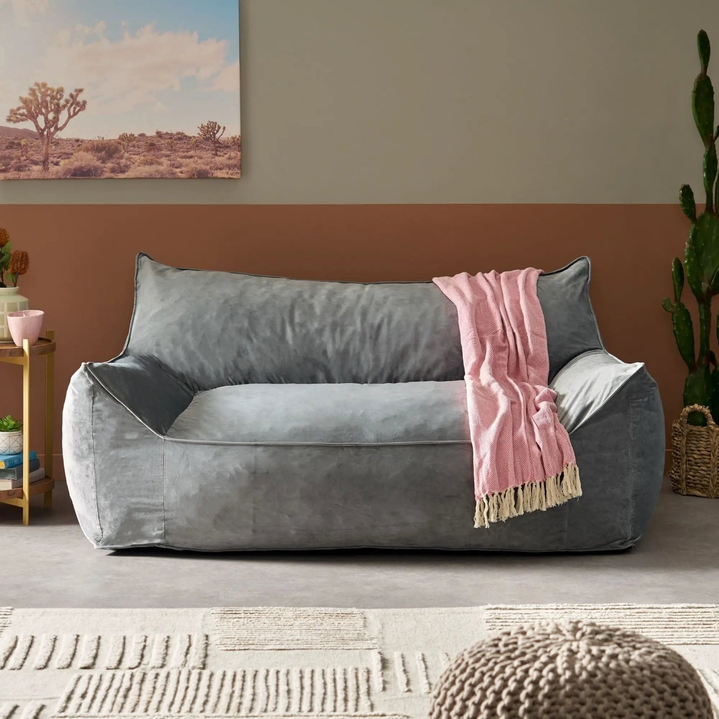 Oversized gray velvet bean bag chair with armrests, pink throw, in a warm living room on Tampa Home & Garden Store