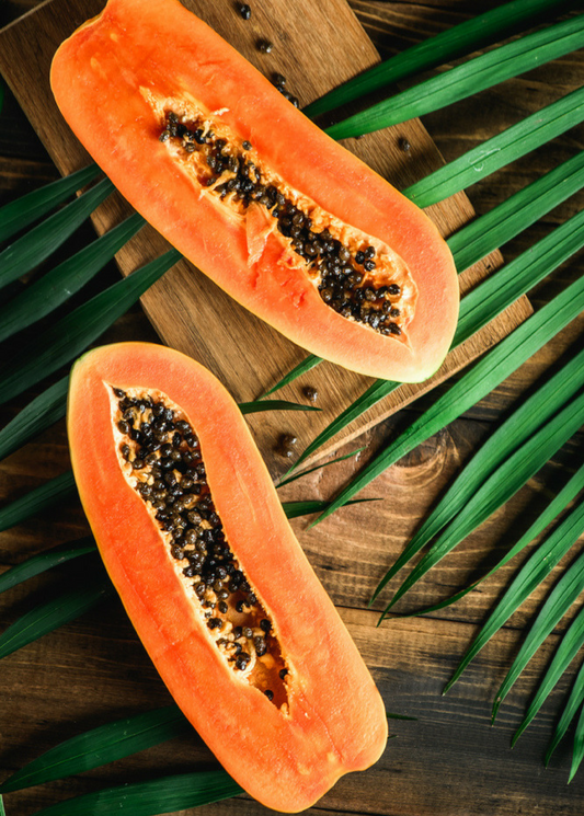 Papaya Dwarf Red Lady fruit halves with orange flesh and black seeds on wooden board on Tampa Home & Garden Store