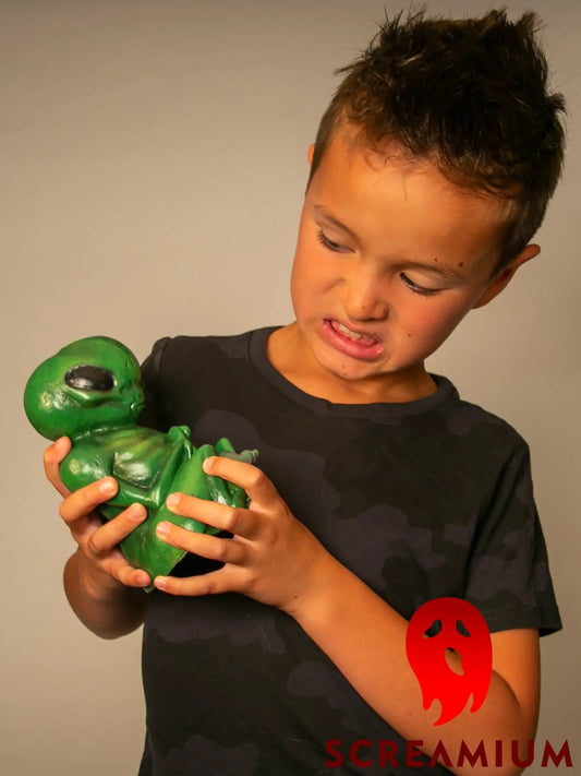 Green Alien Embryo figurine by SCREAMIUM in formaldehyde jar prop held by boy on Tampa Home & Garden Store