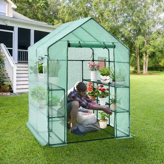 Walk-in greenhouse with green mesh walls and shelves of potted plants on Tampa Home & Garden Store