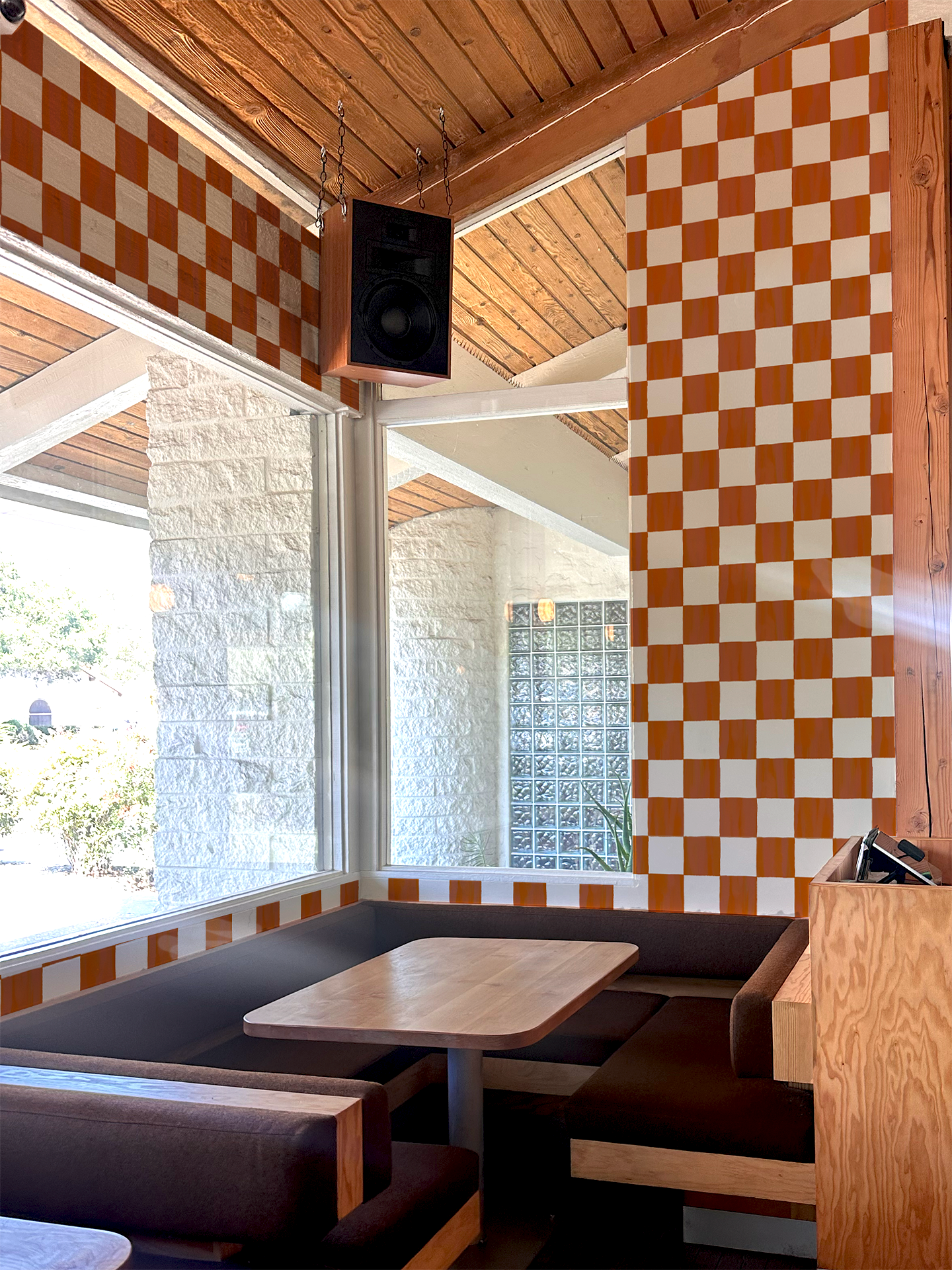 Checkers Wallpaper Rust peel-and-stick in cafe booth with orange and white checker panels on Tampa Home & Garden Store