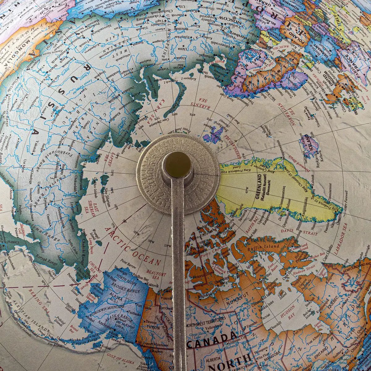 Horizon Ocean Globe desk globe with bronze frame; close-up of the metal axis over a colorful map on Tampa Home & Garden Store