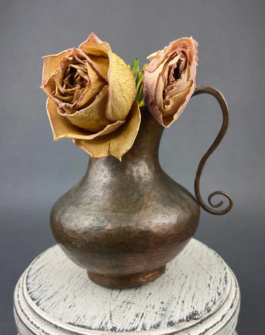 Vintage copper jug hand hammered pitcher with patina and curled handle dried roses decorate the neck on Tampa Home & Garden Store