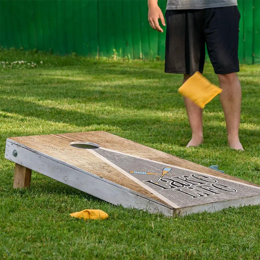 Lake Life cornhole wrap on wooden game board with hole and paddle graphic on lawn on Tampa Home & Garden Store