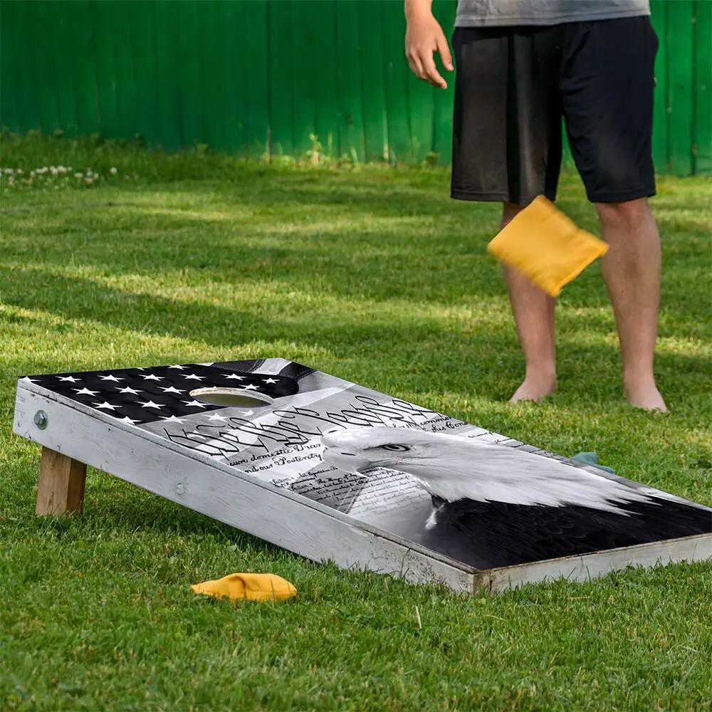 Cornhole board wrap set of 2 with We the People flag design by Lone Star Art on grass on Tampa Home & Garden Store