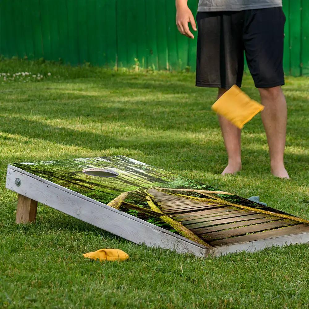 Misty Rainforest Cornhole Board Wrap Set 2 on forest design board with yellow bean bag on grass on Tampa Home & Garden Store