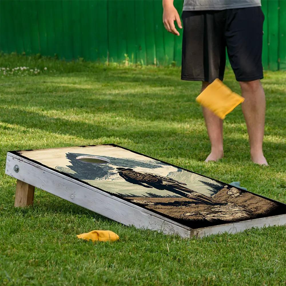 Cornhole board wraps featuring hikers outdoors design on white frame with a yellow bean bag on Tampa Home & Garden Store