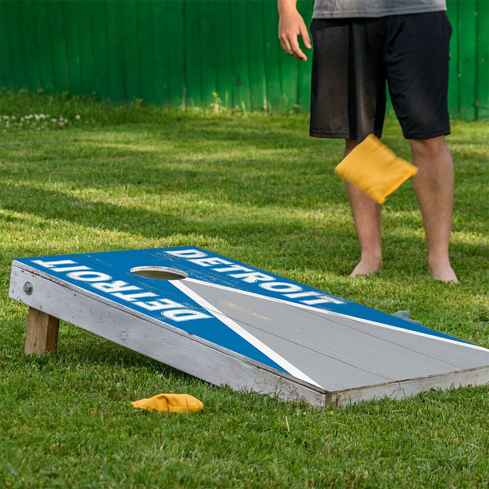 Cornhole wrap set 2 Detroit Football on blue boards with white diagonal stripe on grass on Tampa Home & Garden Store