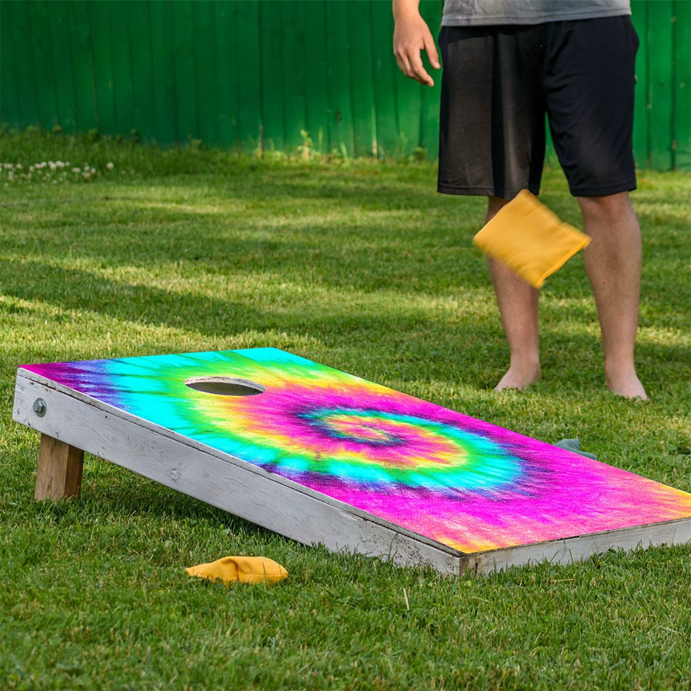 Rainbow tie-dye cornhole board wrap set of 2 on a sunny lawn with a hole on Tampa Home & Garden Store