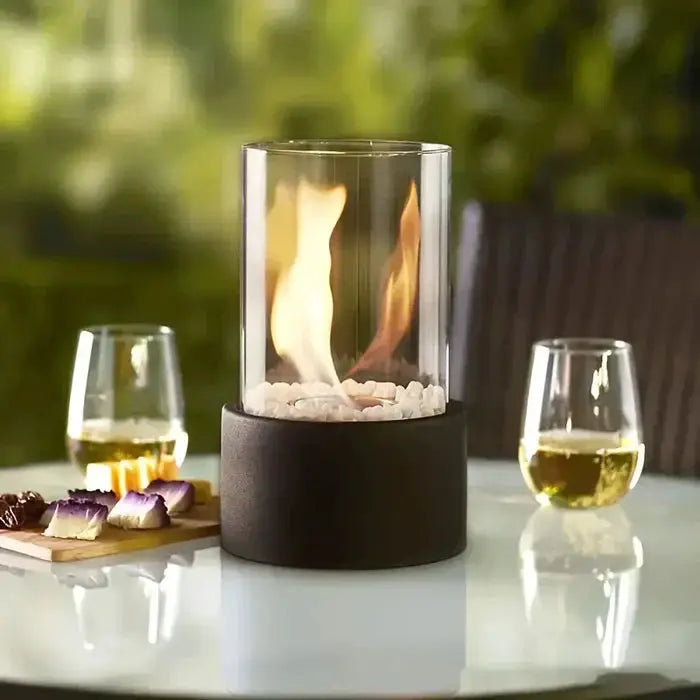 Gas-flame table lantern with glass cylinder on black base; wine glasses on Tampa Home & Garden Store