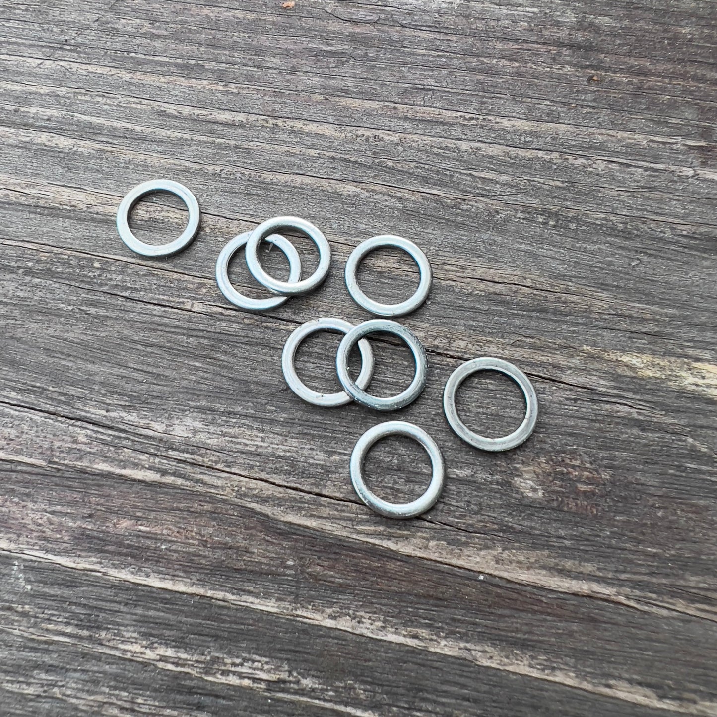 Paris Speed Rings - Silver skateboard small parts, metal rings on weathered wood surface on Tampa Home & Garden Store