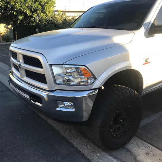 Dodge Ram 30-inch curved light bar brackets front view on white pickup with chrome bumper and oversized off-road tires on Tampa Home & Garden Store