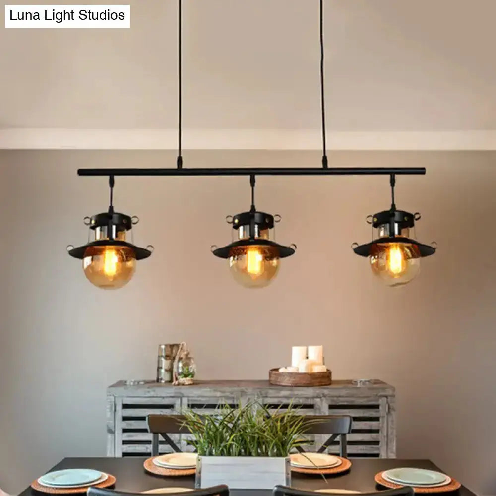 3-light black metal linear island pendant fixture with warm Edison bulbs over dining table on Tampa Home & Garden Store
