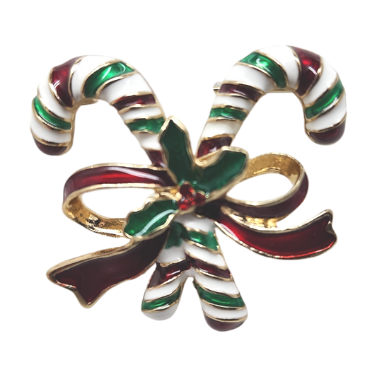 Enamel candy cane bow brooch with red, green, white stripes and holly leaves on Tampa Home & Garden Store