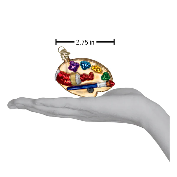 Old World Christmas Artist Palette Glass Ornament with colorful paint dabs and brush in hand on Tampa Home & Garden Store