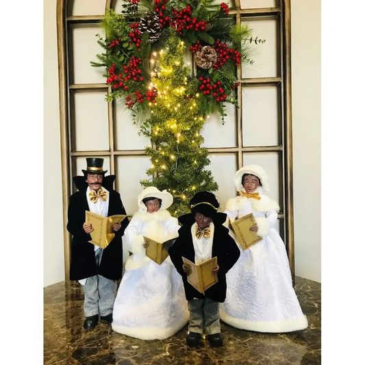 Carolers set of four 18in figures in black coats and white gowns with songbooks before tree on Tampa Home & Garden Store