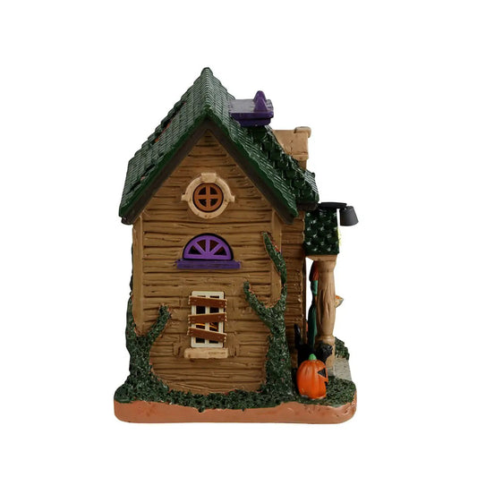 Banshee's Treats and Dark Cottage Secrets village house with green roof and purple accents on Tampa Home & Garden Store