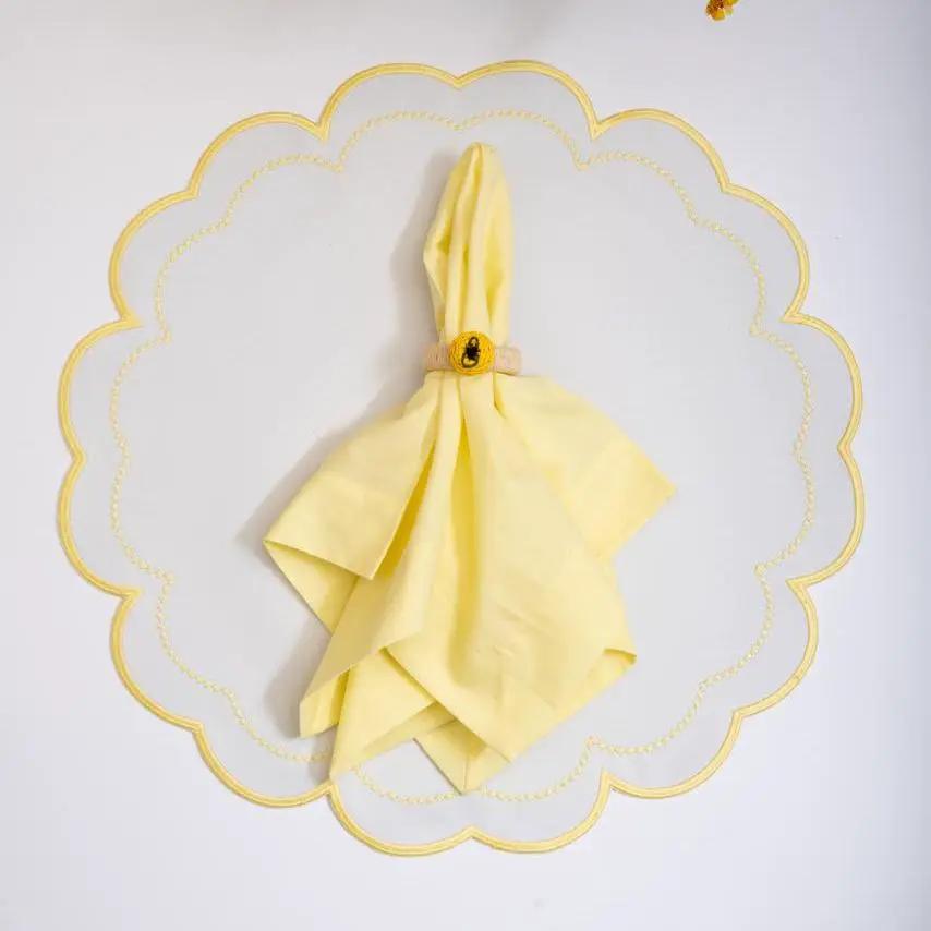 Handwoven lemon napkin ring with raffia detail around a yellow napkin by Talah Home on Tampa Home & Garden Store