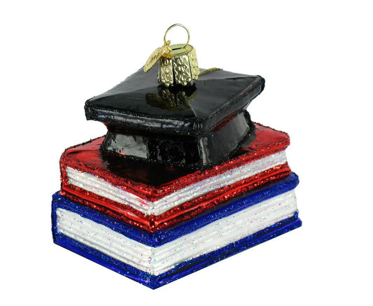 Congratulations Graduate Glass Ornament stack of red white blue books topped with a black cap on Tampa Home & Garden Store
