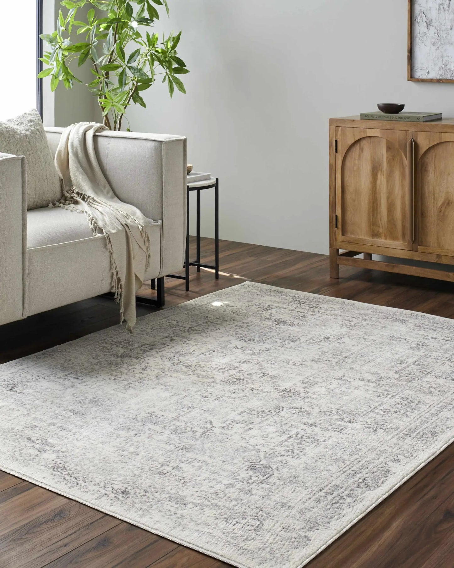 Michie Area Rug in Cream Gray Slate light textured rug on wood floor beside beige sofa and plant on Tampa Home & Garden Store