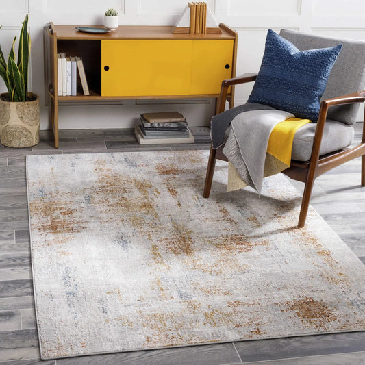 Mustard and Gray Melton Textured Luxe Area Rug in a modern living room with a blue pillow on Tampa Home & Garden Store