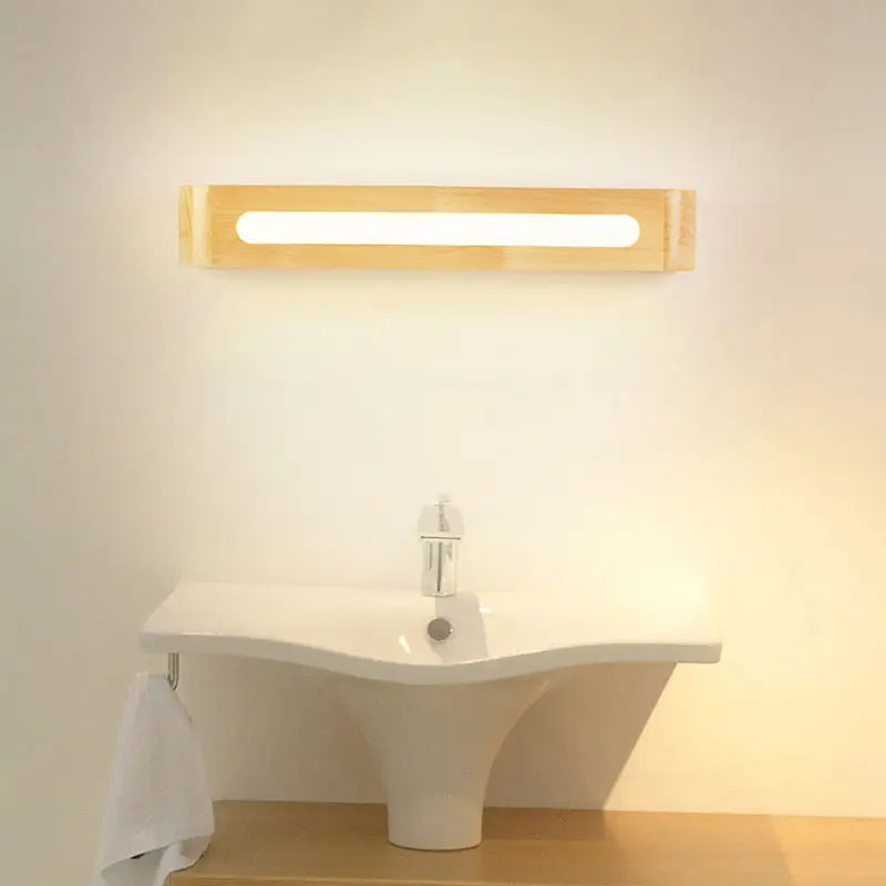 Minimalist bamboo LED wall sconce with warm glow above white bathroom sink on Tampa Home & Garden Store
