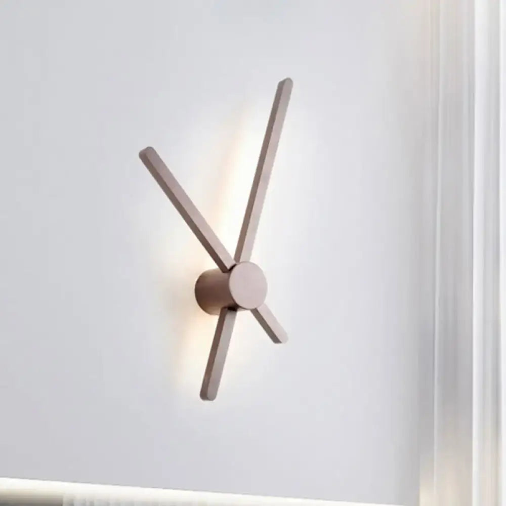 Brown modern wall sconce with four wooden arms forming an asterisk and soft backlit glow on Tampa Home & Garden Store