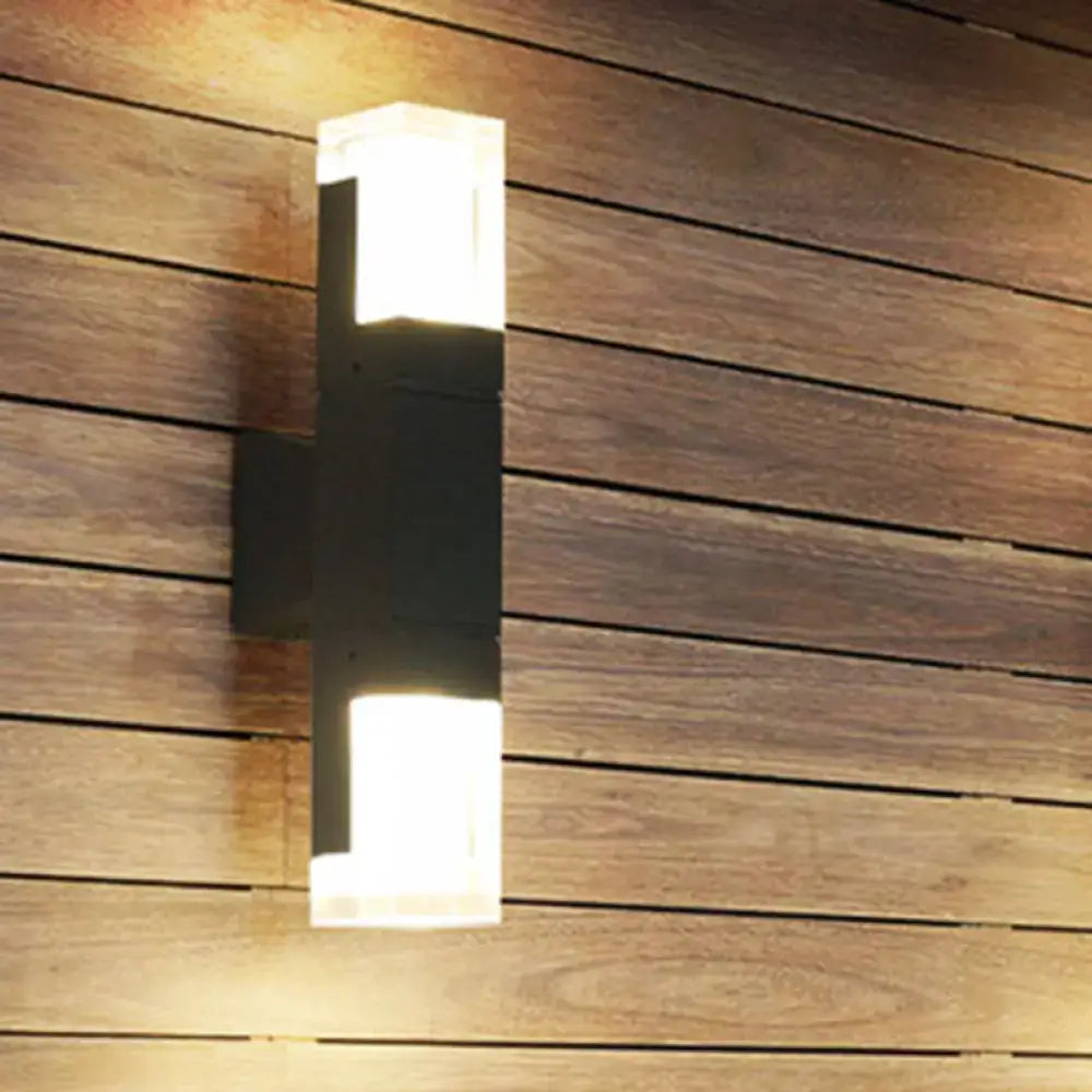 Black LED Courtyard Two-Light Wall Sconce with frosted glass cubes on a wood-paneled wall on Tampa Home & Garden Store
