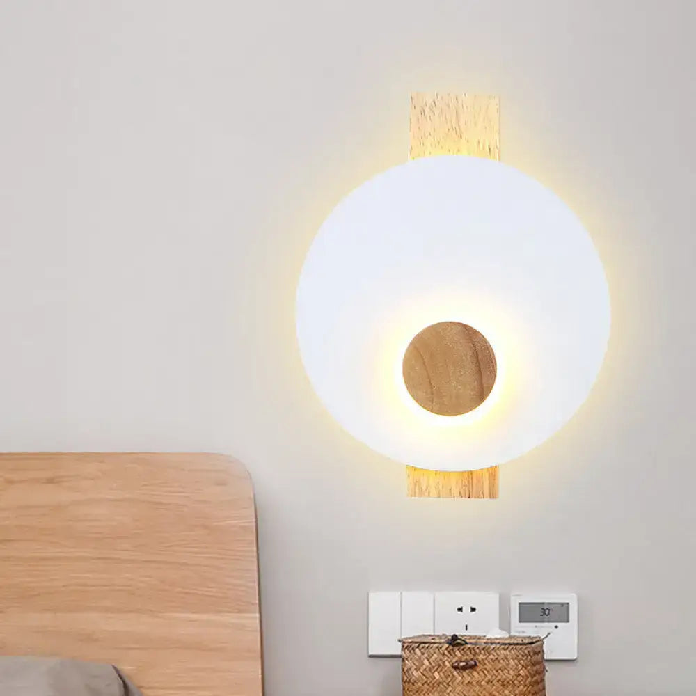 Gray metal disk sconce by Decorbites, wooden backplate, emits warm glow on Tampa Home & Garden Store