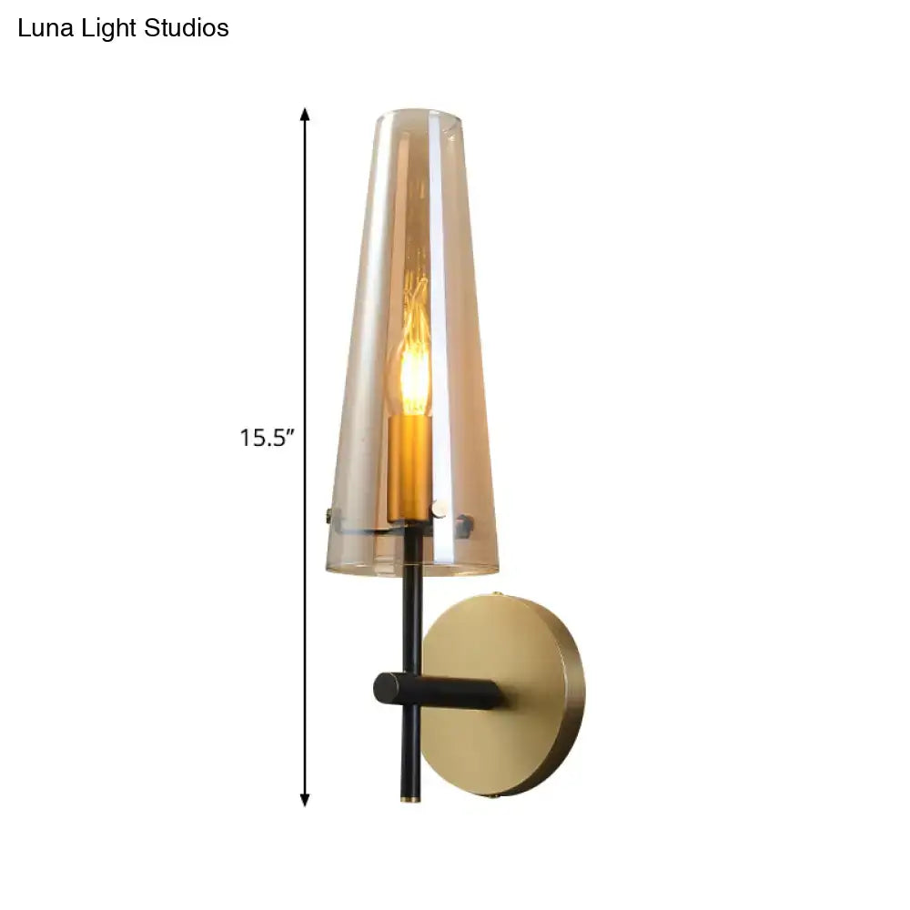 Black brass wall mount sconce with clear glass tapered shade and exposed Edison bulb on Tampa Home & Garden Store
