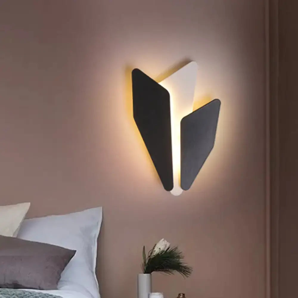 Black geometric metal wall light with three angular panels emitting warm ambient glow on Tampa Home & Garden Store