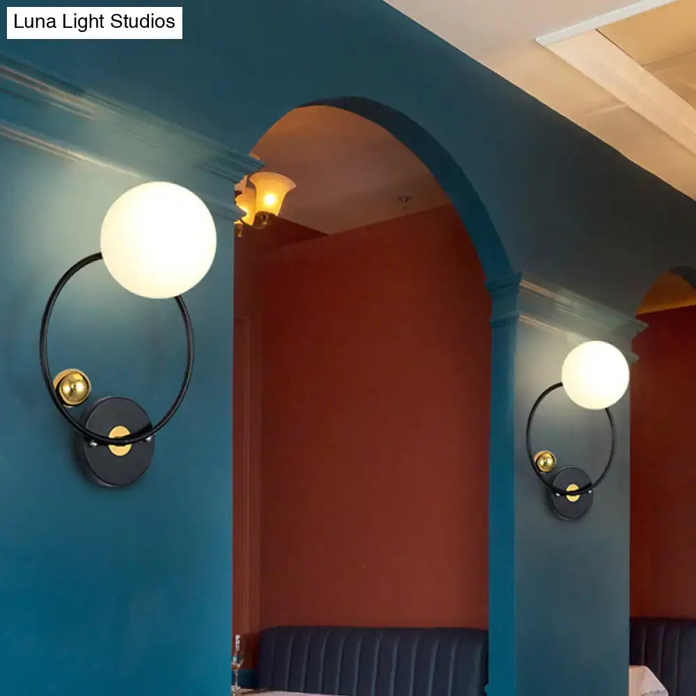 Opal glass circular wall sconce by Decorbites, black ring with brass accent, pair on teal walls on Tampa Home & Garden Store
